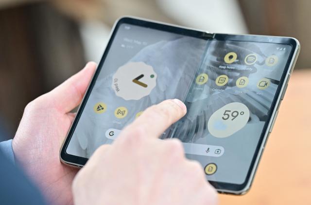 Members of the media view the new Google Pixel Fold phone during the Google I/O annual developers conference at Shoreline Amphitheatre in Mountain View, California on May 10, 2023. (Photo by Josh Edelson / AFP) (Photo by JOSH EDELSON/AFP via Getty Images)