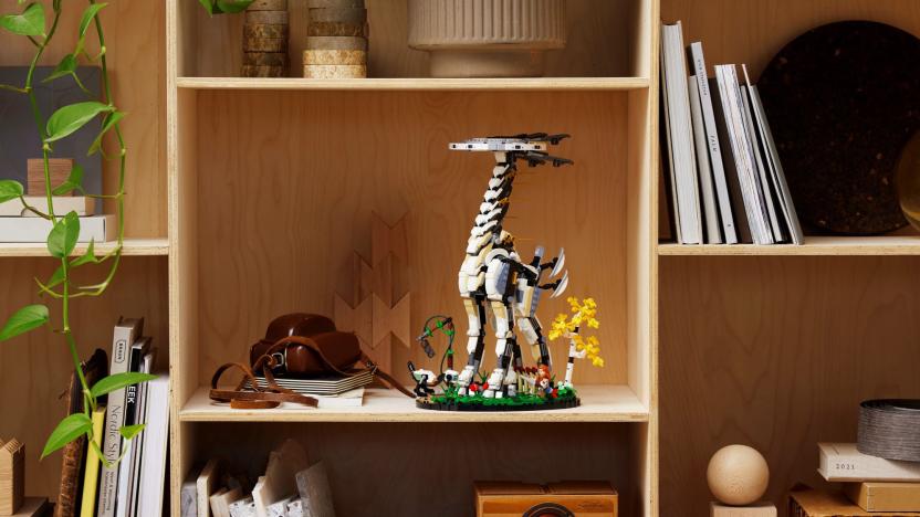 The new Horizon Forbidden West LEGO set with Tallneck seen placed on a shelf filled with books, a camera and other display items.