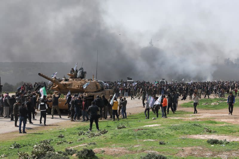 People hold Syrian opposition flags during a protest against an agreement on joint Russian and Turkish patrols, at M4 highway in Idlib province