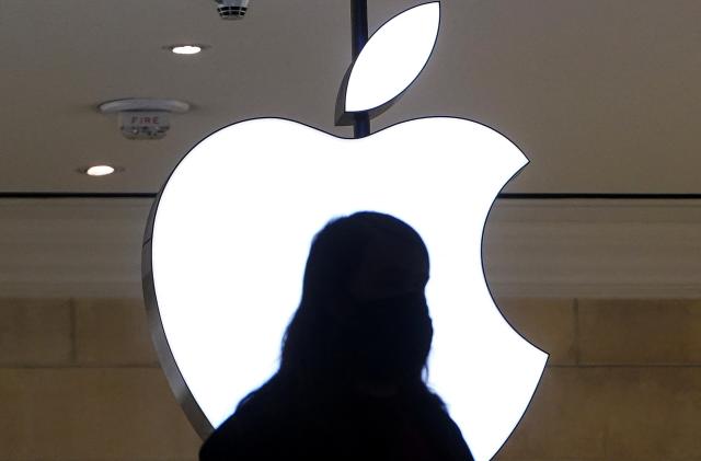 A person is silhouetted against a logo sign of the Apple Store in the Grand Central Terminal in the Manhattan borough of New York City, New York, U.S., January 4, 2022.  REUTERS/Carlo Allegri