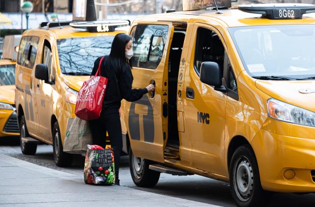 NEW YORK, NEW YORK - MARCH 09: A person enters a yellow cab on the Upper West Side amid the coronavirus pandemic on March 09, 2021 in New York City. It has been one year since COVID-19 was first reported in New York City. After undergoing various shutdown orders for the past 12 months, the city is currently in phase 4 of it's reopening plan, allowing for the reopening of low-risk outdoor activities, movie and television productions, indoor dining as well as the opening of movie theaters, all with capacity restrictions. (Photo by Noam Galai/Getty Images)