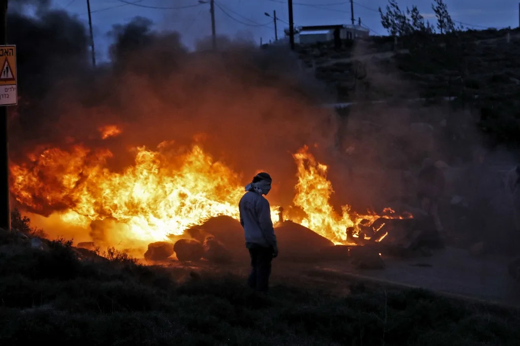 Jewish settlers set tyres ablaze at the Amona outpost, northeast of Ramallah, on February 1, 2017 (AFP Photo/Jack GUEZ)