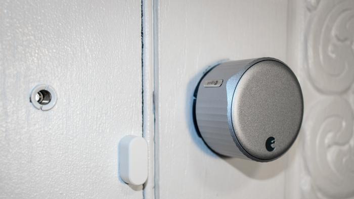 August Smart Lock on a white door.