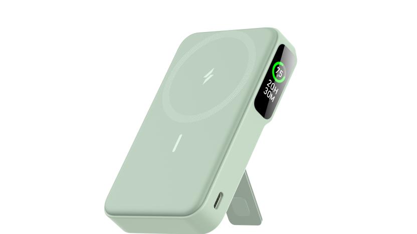 A light moss green charger stands using a kickstand leg on its rear, showing the magnetic front panel and a small display along the side. 