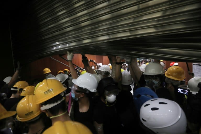 The steel shutters proved little match for the protesters who used polls to prise the shutters up high enough to place metal barricades underneath and allow people to flood through (AFP Photo/VIVEK PRAKASH)