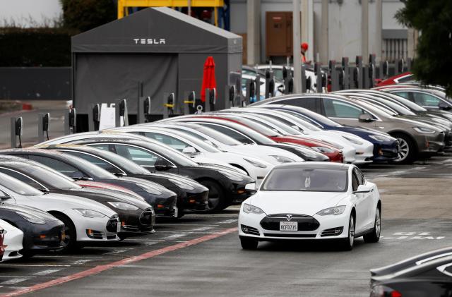 A Tesla Model S electric vehicle drives along a row of occupied superchargers at Tesla's primary vehicle factory after CEO Elon Musk announced he was defying local officials' restrictions against the coronavirus disease (COVID-19) by reopening the plant in Fremont, California, U.S. May 12, 2020. REUTERS/Stephen Lam