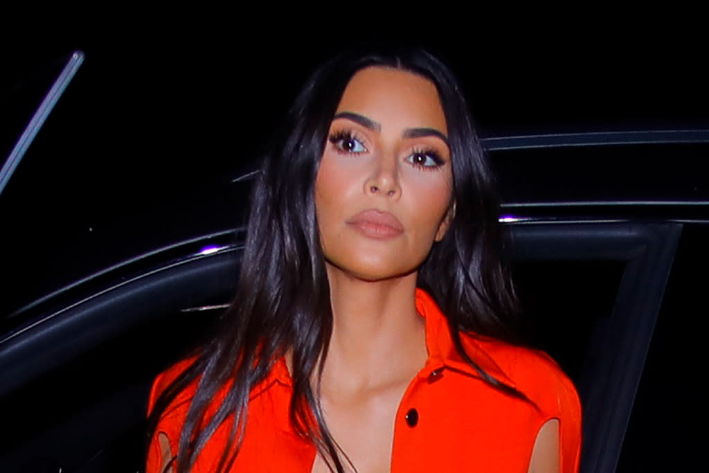 Kim Kardashian Pops in a cropped cherry red top, leather pants and flickering stiletto boots