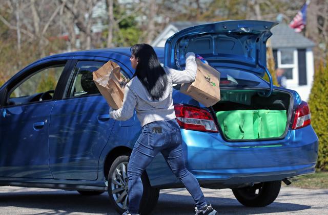 FALMOUTH, MA - APRIL 8: Instacart shopper Loralyn Geggatt makes a delivery to a customer's home during the COVID-19 pandemic in Falmouth, MA on April 7, 2020. Some Amazon, Instacart and other workers protested for better wages, hazard pay and sick time. (Photo by David L. Ryan/The Boston Globe via Getty Images)