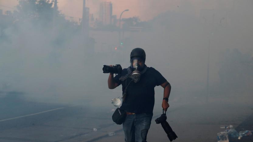 A photographer runs amid tear gas as demonstrations continue following the death in Minneapolis police custody of George Floyd, in Minneapolis, Minnesota, U.S. May 30, 2020. REUTERS/Carlos Barria