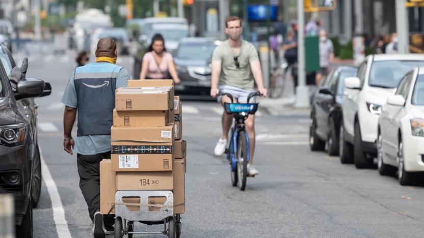 NEW YORK, NEW YORK - SEPTEMBER 25: An Amazon Prime delivery person wheels a hand cart with Amazon packages as the city continues Phase 4 of re-opening following restrictions imposed to slow the spread of coronavirus on September 25, 2020 in New York City. The fourth phase allows outdoor arts and entertainment, sporting events without fans and media production.  (Photo by Alexi Rosenfeld/Getty Images)