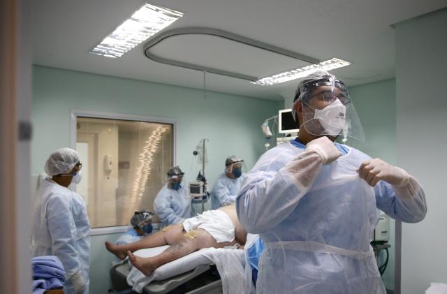 A medical worker is seen near a patient at the intensive care unit (ICU) of the Nossa Senhora da Conceicao hospital, during the coronavirus disease (COVID-19) outbreak, in Porto Alegre, Brazil, November 19, 2020. Picture taken November 19, 2020. REUTERS/Diego Vara