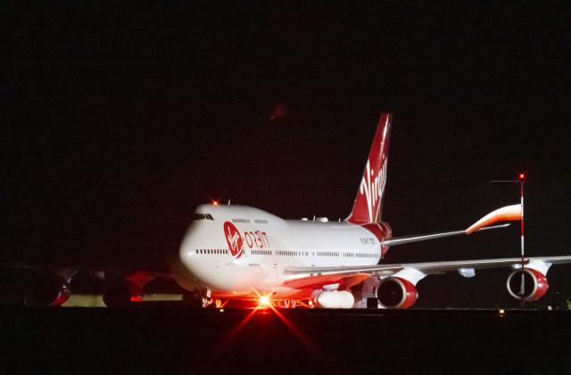 NEWQUAY, ENGLAND - JANUARY 09: A general view of Cosmic Girl, a repurposed Boeing 747 aircraft carrying the LauncherOne rocket under its left wing, as final preparations are made at Cornwall Airport Newquay on January 9, 2023 in Newquay, United Kingdom. Virgin Orbit launches its LauncherOne rocket from the spaceport in Cornwall, marking the first ever orbital launch from the UK. The mission has been named Start Me Up after the Rolling Stones hit. (Photo by Matthew Horwood/Getty Images)