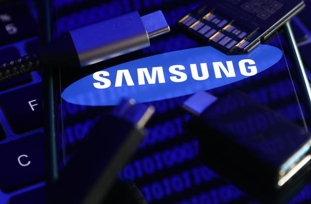 Samsung logo displayed on a phone screen with a binary code reflected on it, a laptop keyboard, a memory card, an adaper and cables are seen in this illustration photo taken in Krakow, Poland on January 30, 2023. (Photo by Jakub Porzycki/NurPhoto via Getty Images)