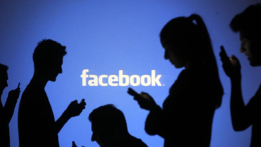 People are silhouetted as they pose with mobile devices in front of a screen projected with a Facebook logo, in this picture illustration taken in Zenica October 29, 2014. Facebook Inc warned on Tuesday of a dramatic increase in spending in 2015 and projected a slowdown in revenue growth this quarter, slicing a tenth off its market value. Facebook shares fell 7.7 percent in premarket trading the day after the social network announced an increase in spending in 2015 and projected a slowdown in revenue growth this quarter.   REUTERS/Dado Ruvic (BOSNIA AND HERZEGOVINA  - Tags: BUSINESS SCIENCE TECHNOLOGY BUSINESS LOGO)