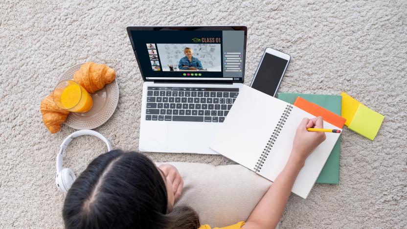 Asian female student video conference with teacher and friends using e-learing app on laptop computer at home.woman lying down on carpet.new normal learning online lifestyle