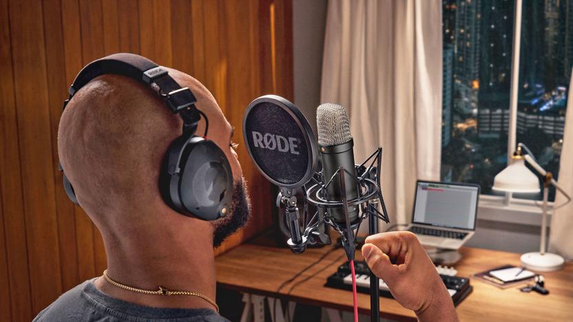 A man with a small home studio setup speaks into the new Rode NT1 microphone.