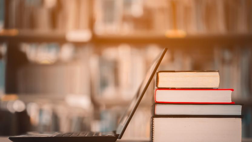 Bookshelves and laptops are placed on the library desk.E-learning class and e-book digital technology