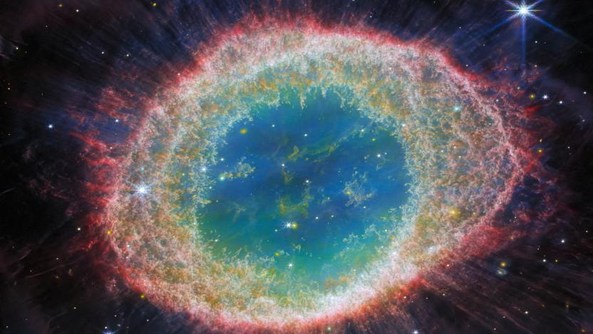 Detailed image of the Ring Nebula, captured by the Webb Telescope. It's an enormous gassy ring with reddish outer rings, which move towards more green and blue near the center.