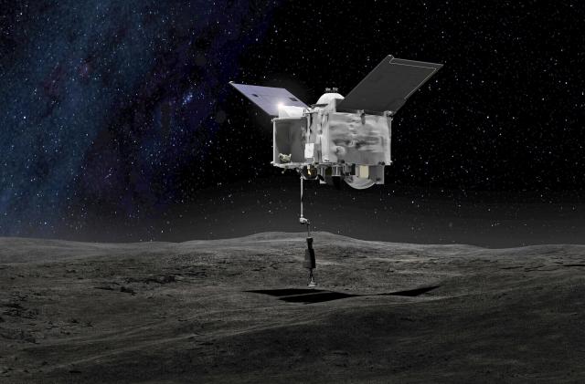 Esta representación artística, proporcionada por la NASA el 6 de septiembre de 2016, muestra a la nave espacial OSIRIS-REx tomando muestras del asteroide Bennu. 