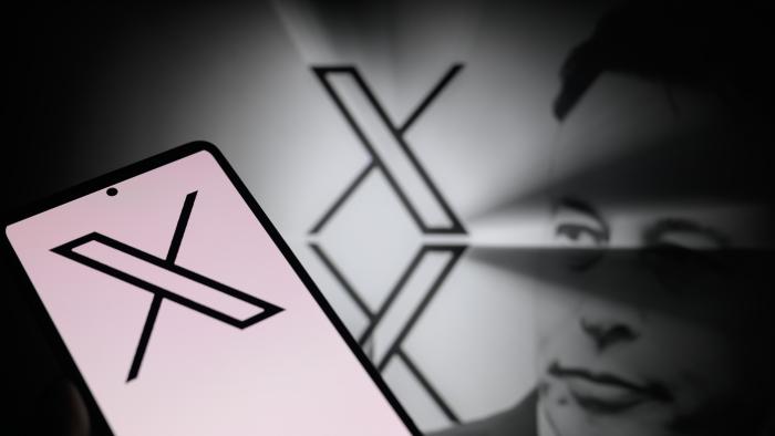 The X logo is being displayed on a smartphone, with the X app, formerly known as Twitter, and X visible in the background, in this photo illustration taken in Brussels, Belgium, on January 5, 2024. (Photo by Jonathan Raa/NurPhoto via Getty Images)