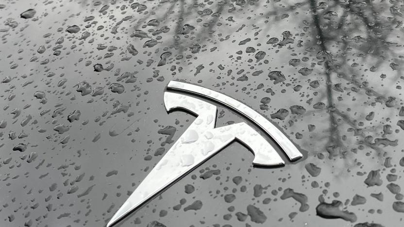 Raindrops are seen next to the Tesla logo on the bonnet of a Tesla electric car in Berlin's Kreuzberg district on January 8, 2023. - Tesla has delivered 1.31 million electric vehicles in 2022 -- a record for the US automaker and a 40 percent jump from a year before, but still short of its own and Wall Street's expectations. (Photo by David GANNON / AFP) (Photo by DAVID GANNON/AFP via Getty Images)