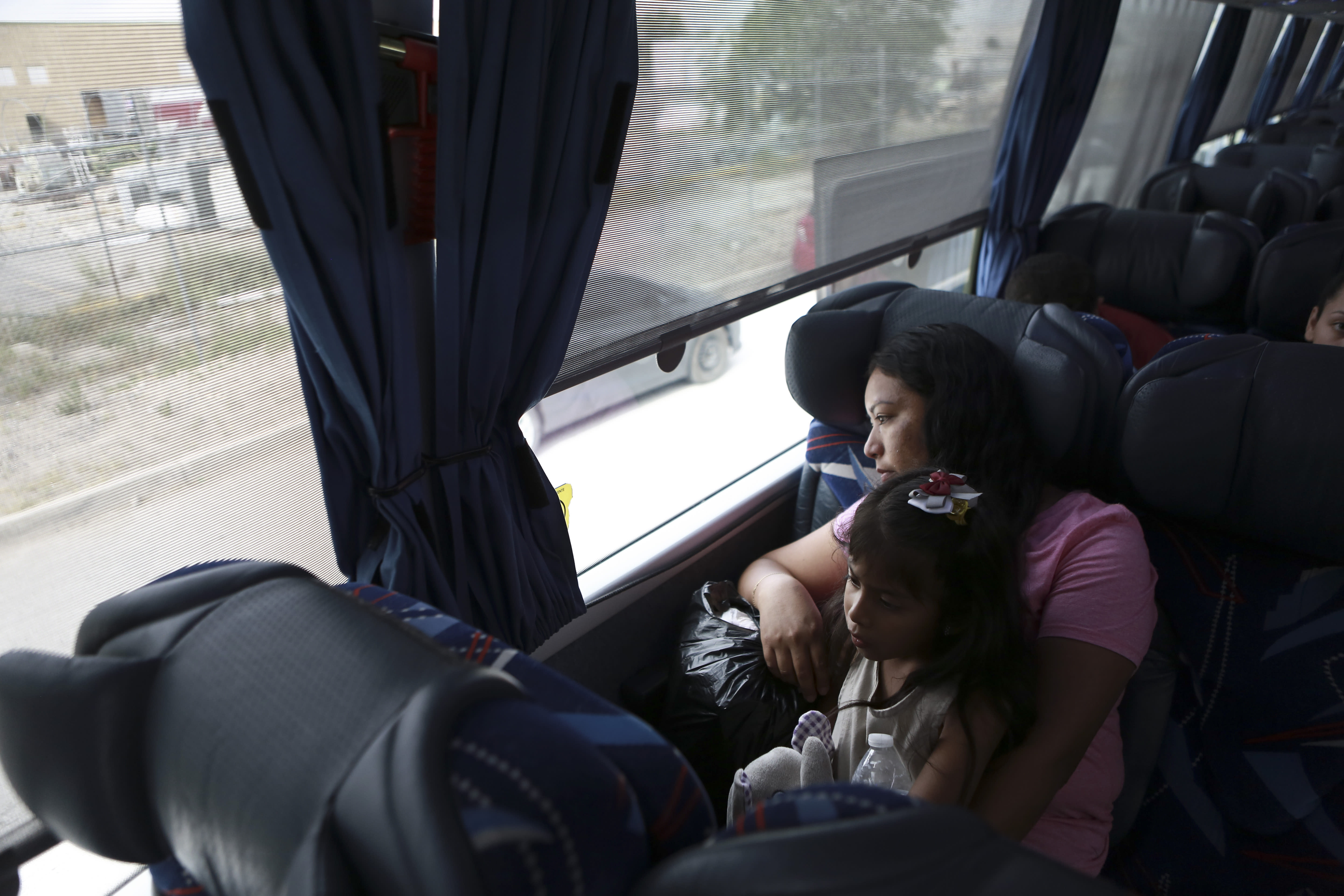 A Central American migrant woman and child wait in a bus after deciding to voluntarily return to their country, in Ciudad Juarez, Mexico, Tuesday, July 2, 2019. Dozens of Central Americans who had been returned to the border city of Juarez to await the outcome of their U.S. asylum claims are being bused back to their countries Tuesday by Mexican authorities, a first for that size group of people in the program commonly known as âremain in Mexico.â (AP Photo/Christian Chavez)