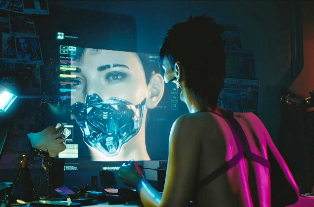 A promotional still from the video game Cyberpunk 2077, with an android sitting at a computer.