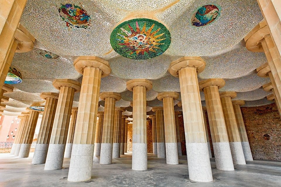 His investigation into classical architecture extended to Barcelona’s Parc Güell, where Doric-inspired columns fill the market hall. But in signature Gaudí style, the ceiling is decorated with colorful mosaics. The park was built between 1900 and 1914.