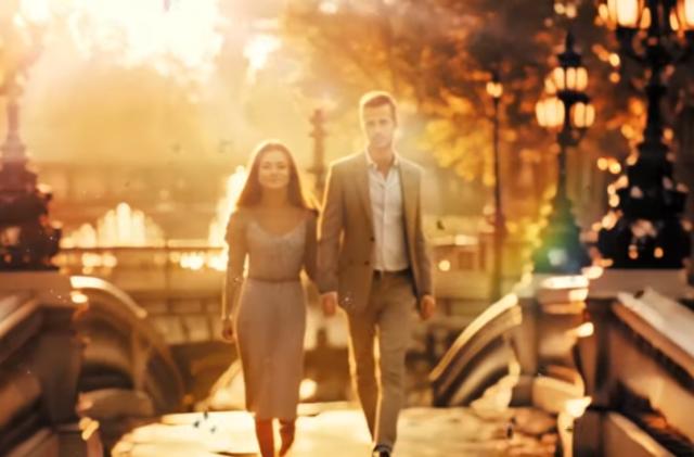 A man and woman walk hand-in-hand over a bridge at sunset.