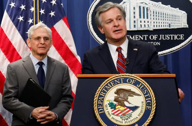 Federal Bureau of Investigation (FBI) Director Christopher Wray, with U.S. Attorney General Merrick Garland, answers a reporter's question at a news conference announcing charges against two Chinese nationals for trying to obstruct the prosecution of China's Huawei Technologies Co Ltd, and four others with trying to spy for Beijing, at the Justice Department in Washington, U.S. October 24, 2022.  REUTERS/Jonathan Ernst