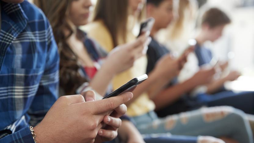 Close Up Of A Line Of High School Students Using Mobile Phones