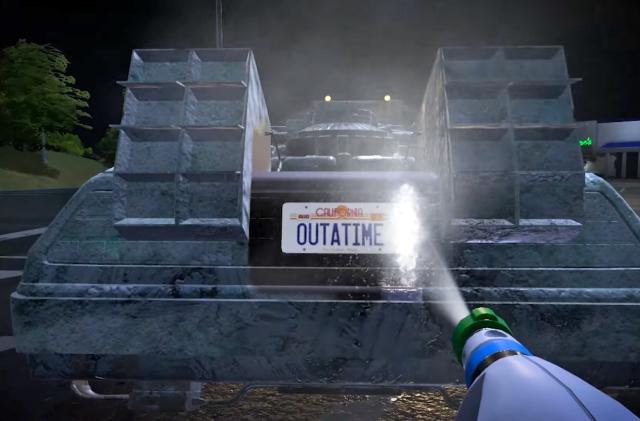 A powerwasher blasts water onto a license plate reading "California OUTATIME" on the back of a DeLorean in PowerWash Simulator.