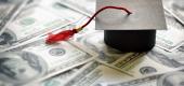 Graduation mortarboard cap on $100 bills. (Getty Images)