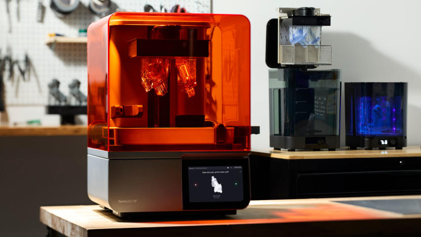 Image of the new Formlabs Form 4 3D printer on a workbench, with other Formlabs' accessories in the background and a pinboard with tools in the blur.