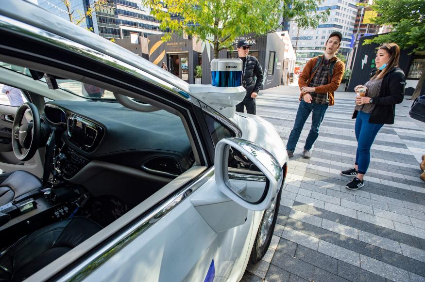 Event attendees inspect an autonomous car by Motional at the Robot Block Party put on by MassRobotoics in Boston, Massachusetts on October 2, 2021. - Leading Robotic companies showcased their latest products as well as design concepts to introduce the public to the future in robotics, from drones to autonomous cars. (Photo by Joseph Prezioso / AFP) (Photo by JOSEPH PREZIOSO/AFP via Getty Images)