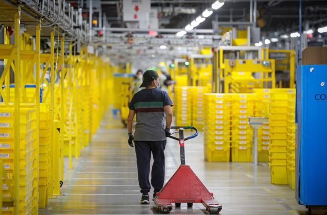 An employee pulls a cart at Amazon's JFK8 distribution center in Staten Island, New York, U.S. November 25, 2020.  REUTERS/Brendan McDermid.