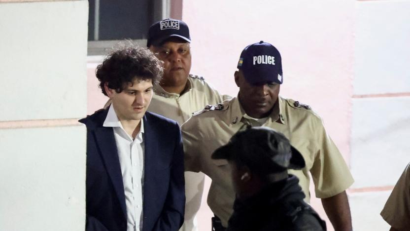 Sam Bankman-Fried, who founded and led FTX until a liquidity crunch forced the cryptocurrency exchange to declare bankruptcy, is escorted out of the Magistrate Court building after his arrest, in Nassau, Bahamas December 13, 2022. REUTERS/Dante Carrer