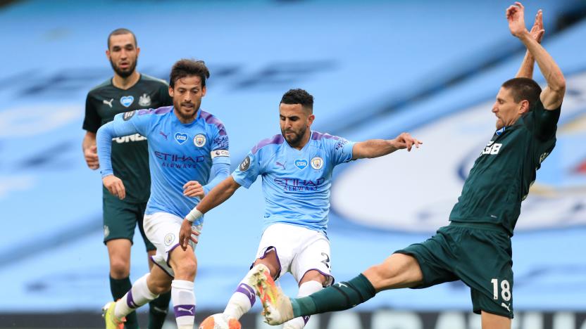 MANCHESTER, ENGLAND - JULY 08: Riyad Mahrez of Man City shoots as Federico Fernandez of Newcastle lunges in to challenge during the Premier League match between Manchester City and Newcastle United at Etihad Stadium on July 8, 2020 in Manchester, United Kingdom. (Photo by Simon Stacpoole/Offside/Offside via Getty Images)