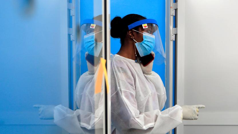 A healthcare worker wearing protective gear talks on a mobile phone at a testing center for the coronavirus disease (COVID-19) of the Institute for Health Research, Epidemiological Surveillance and Training (IRESSEF), in Dakar, Senegal July 24, 2020. REUTERS/Zohra Bensemra     TPX IMAGES OF THE DAY