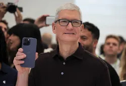 Apple CEO Tim Cook holds the new iPhone 14 at an Apple event at their headquarters in Cupertino, California, U.S. September 7, 2022. REUTERS/Carlos Barria