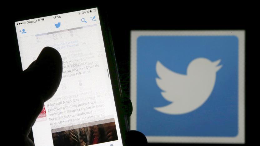 A man reads tweets on his phone in front of a displayed Twitter logo in Bordeaux, southwestern France, March 10, 2016. REUTERS/Regis Duvignau/Illustration/File Photo