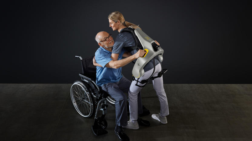 A nurse helping a patient while wearing an exosuit. 