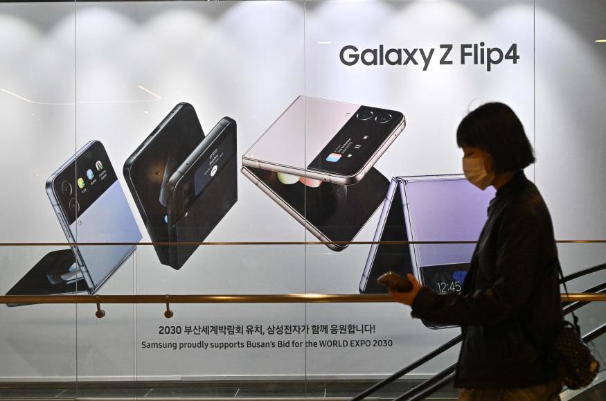 A woman walks past an advertisement for the Samsung Galaxy Z Flip4 smartphone at the company's Seocho building in Seoul on October 7, 2022, after Samsung Electronics expected operating profits in the third quarter to fall 31.7 percent. (Photo by Jung Yeon-je / AFP) (Photo by JUNG YEON-JE/AFP via Getty Images)
