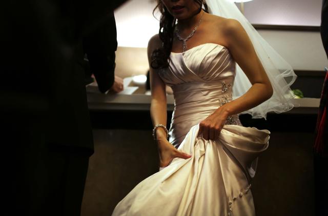 NEW YORK, NY - DECEMBER 12:  A bride waits to fill out marriage papers at a busy City Clerk's office on December 12, 2012 in New York City. Couples around the world are hoping that a once-in-a-lifetime event, the date 12/12/12, will bring added luck to their marriages if they tie the knot today. This will be the last such triple date for almost a century, until January 1, 2101.  (Photo by Spencer Platt/Getty Images)