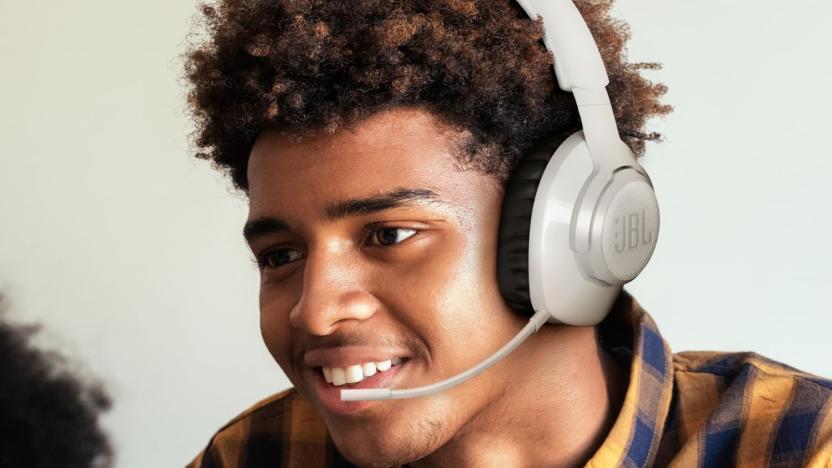 A young man smiling while wearing a JBL gaming headset