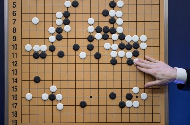 A commentator in a media room positions pieces forming a replica of a game between 'Go' player Lee Se-Dol and a Google-developed super-computer, in Seoul on March 13, 2016.
A South Korean Go grandmaster scored his first win over a Google-developed supercomputer, in a surprise victory after three humiliating defeats in a high-profile showdown between man and machine. Lee Se-Dol thrashed AlphaGo after a nail-biting match that lasted for nearly five hours -- the fourth of the best-of-five series in which the computer clinched a 3-0 victory on March 12. 
 / AFP PHOTO / Ed Jones        (Photo credit should read ED JONES/AFP via Getty Images)