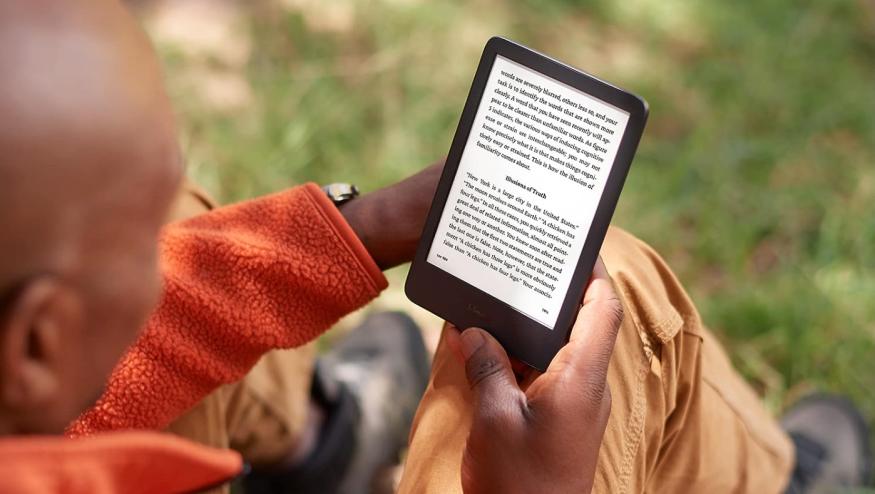 A bald man reading a Kindle.