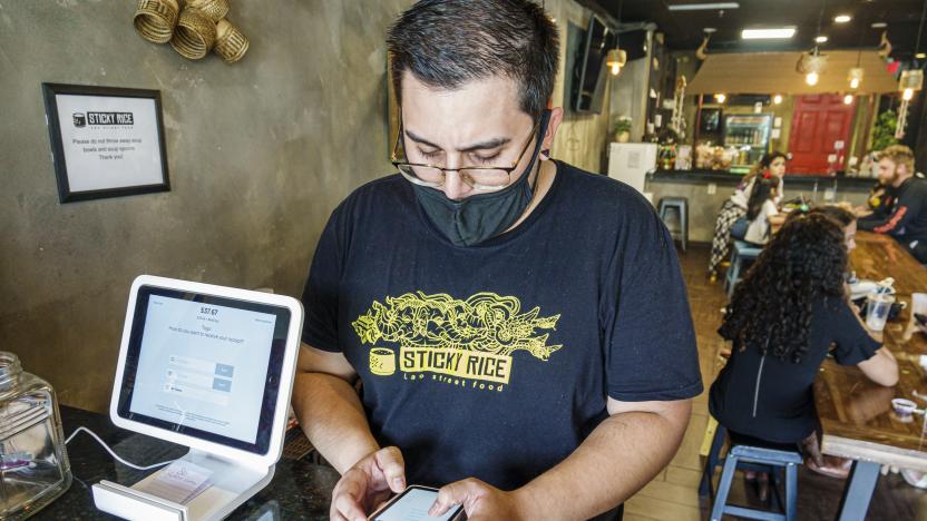 A Sticky Rice Lao Street Food employee processes a Square credit card reader in Little Saigon, Orlando, Florida. (Photo by: Jeffrey Greenberg/Education Images/Universal Images Group via Getty Images)