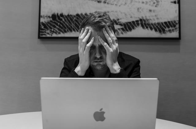 Image of a sad person staring into a computer.