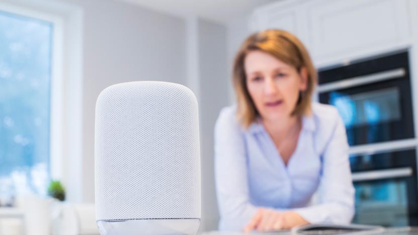 Woman In Kitchen Asking Digital Assistant Question